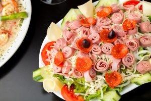 22819657 - a delicious looking tossed chefs salad or antipasto with meat cheese and kalamata olives.